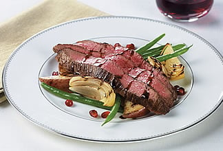 Pomegranate glazed flank steak on potato wedges and beans