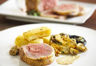 Roasted loin of lamb with thick cut fries and wild mushrooms